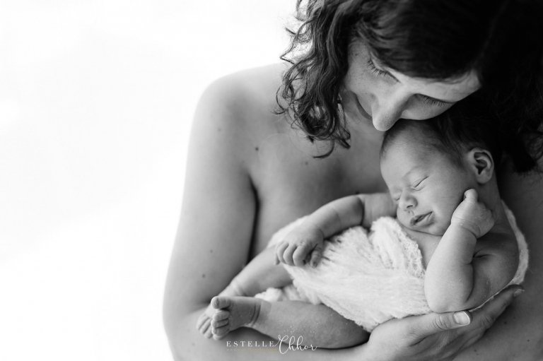 photo en noir et blanc de bébé souriant dans les bras de maman