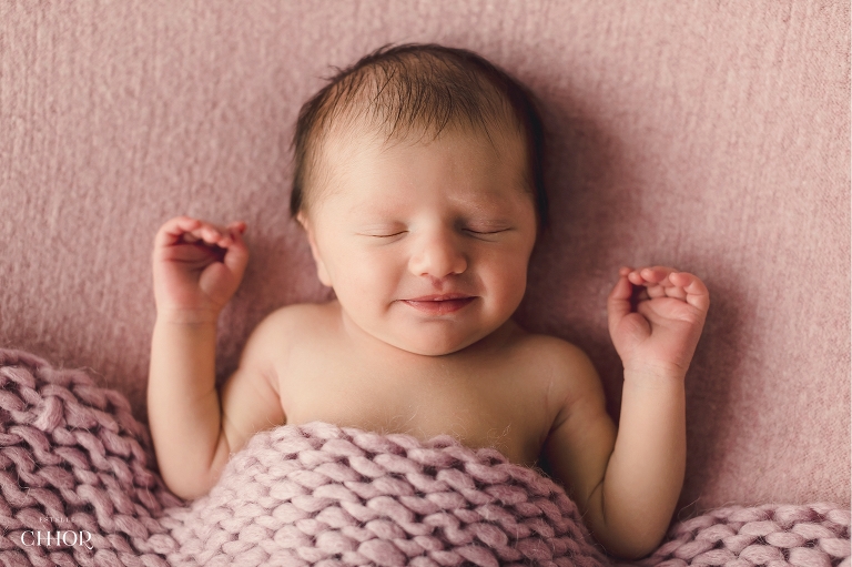 bébé qui sourit couverture rose